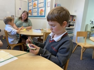 Upper Prep pupils weaving colourful yarn around conkers to create decorative patterns that build fine motor skills and coordination.