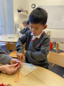 Upper Prep pupils weaving colourful yarn around conkers to create decorative patterns that build fine motor skills and coordination.