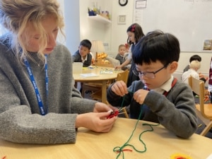 Upper Prep pupils weaving colourful yarn around conkers to create decorative patterns that build fine motor skills and coordination.