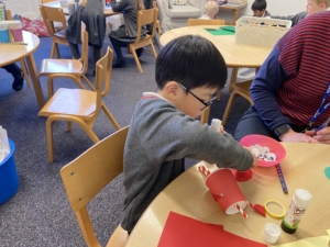 Upper Prep pupil assembling a puppet using a paper cup and coloured paper.