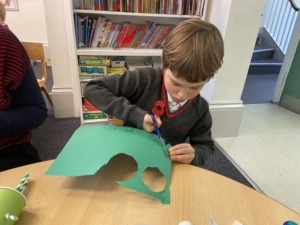 Upper Prep pupil assembling a puppet using a paper cup and coloured paper.