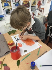 Year 2 pupils work with paint in this enrichment session