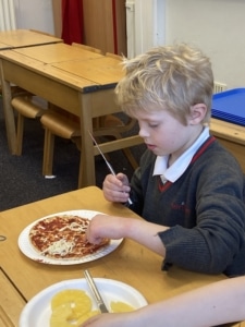 Heritage Year 2 pupils make pizzas during an enrichment session