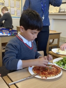 Heritage Year 2 pupils make pizzas during an enrichment session