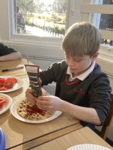 Heritage Year 2 pupils make pizzas during an enrichment session
