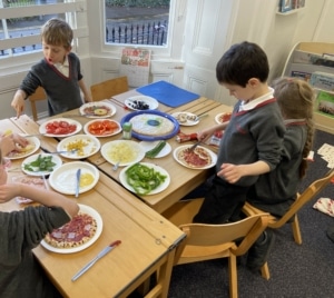 Heritage Year 2 pupils make pizzas during an enrichment session