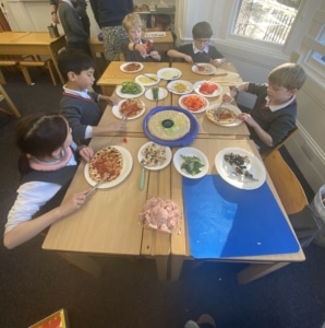 Heritage Year 2 pupils make pizzas during an enrichment session