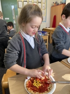 Heritage Year 2 pupils make pizzas during an enrichment session